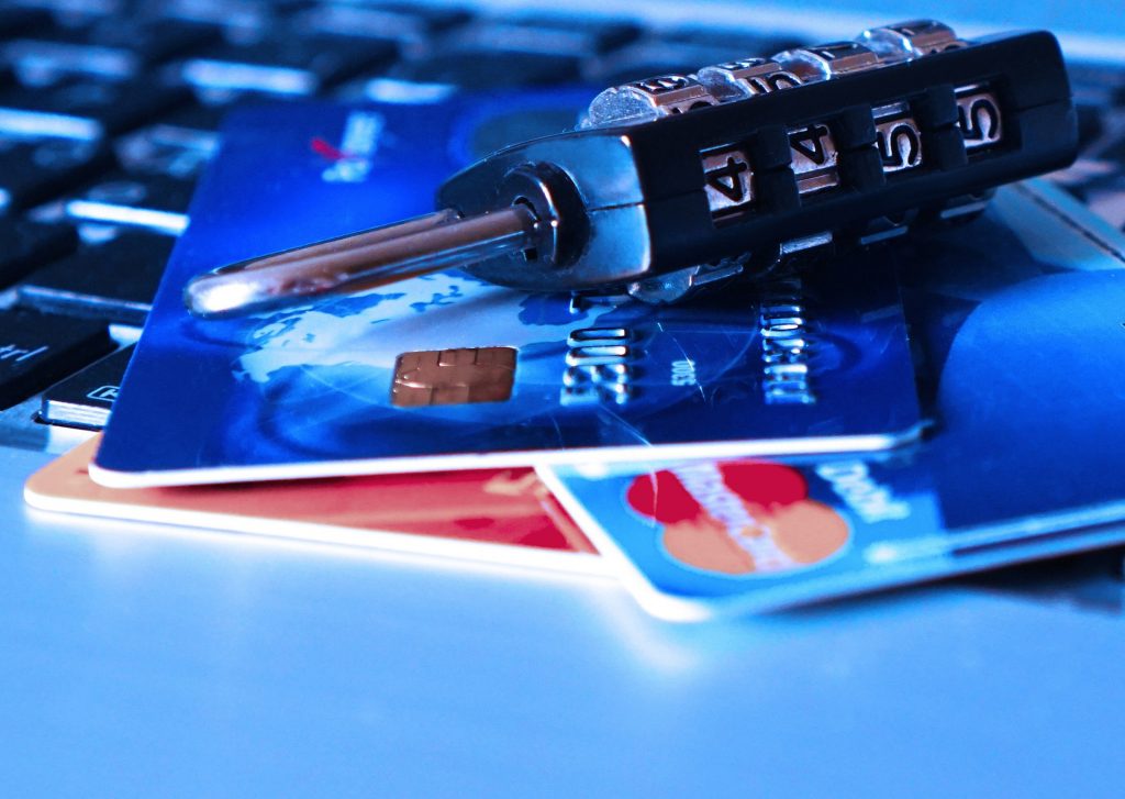 A padlock and bank cards on a keyboard.